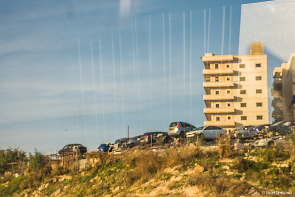 Car Junkyard in Front of Large Modern Arab Buildings East of Jer