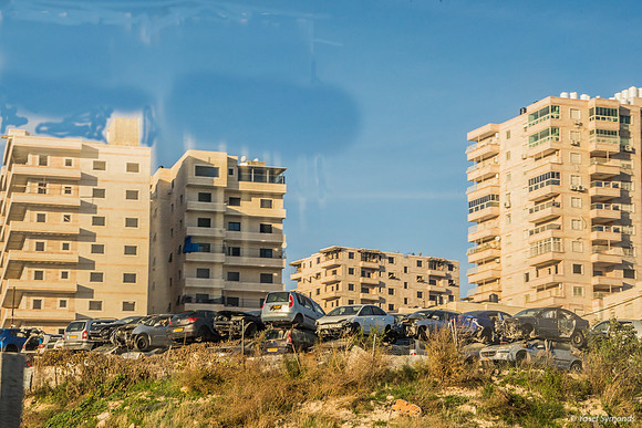 Car Junkyard in Front of Large Modern Arab Buildings East of Jer